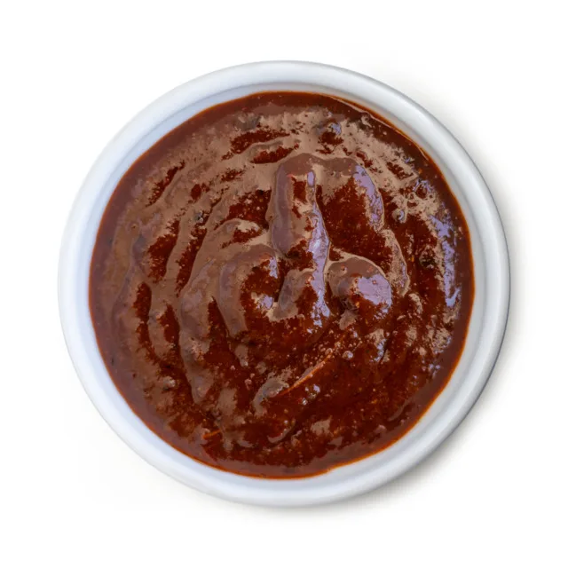 Rich, smooth chili concentrate in white bowl, ideal for wholesale food distributors and commercial food manufacturers.
