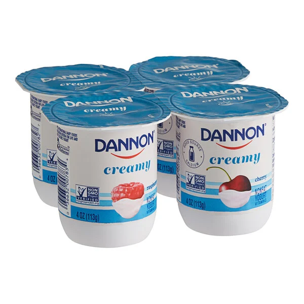 Four-pack of Dannon creamy yogurt cups with fruit flavors, ideal for foodservice and wholesale distribution in commercial food supply.