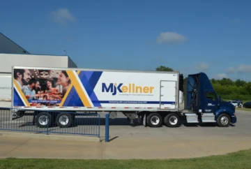 MJKellner commercial food service distribution truck parked at loading facility, showcasing family-owned wholesale food supplier serving businesses since 1920.