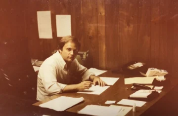 A professional man working at a desk with documents and paperwork, representing administrative and management operations in the food supply industry.
